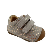 Load image into Gallery viewer, A single toddler shoe by Geox, featuring a taupe suede upper with rose gold sequins, dual hook-and-loop straps, and a brown rubber sole, shown on a light gray background.