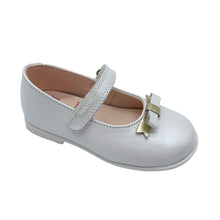 Load image into Gallery viewer, A white Mary Jane style shoe with a bow and metallic embellishment, featuring a hook and loop closure and a leather insole.